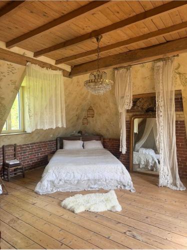a bedroom with a bed and a chandelier at Les séquoias géants in Saint-Martin-aux-Arbres