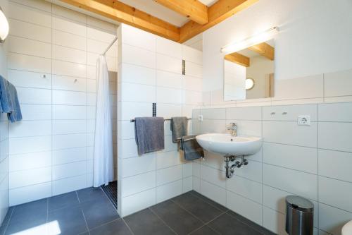 a white bathroom with a sink and a mirror at Dieboldshof in Neuried