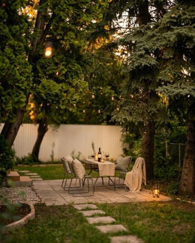 a table and chairs in a yard with trees at Bánhiday M4 Weekendhouse in Balatonakarattya