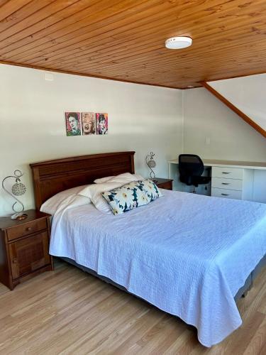 a bedroom with a large bed with a blue blanket at Hermosa casa en Talca in Talca