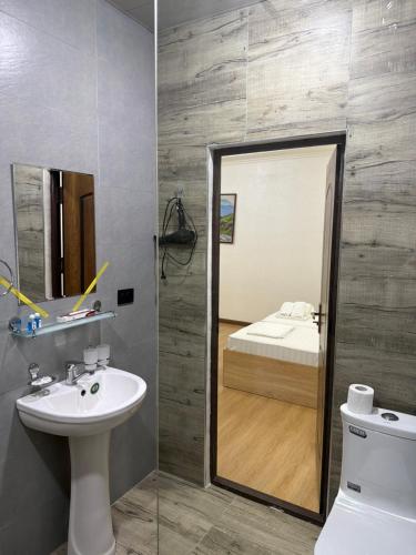 a bathroom with a sink and a mirror and a bed at ART Dream Hotel in Tashkent