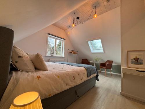 a bedroom with a large bed in a attic at De Strandloper B&B Oostduinkerke in Koksijde