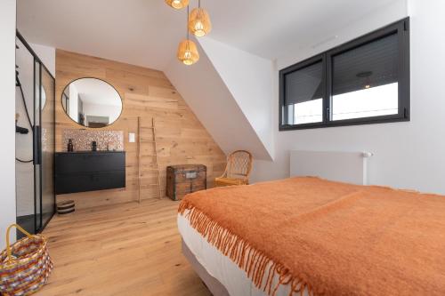 a bedroom with a large bed and a mirror at Maison Desmathi in Saint-Pierre-Quiberon