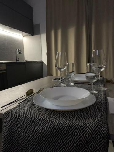 a table with two plates and wine glasses on it at attico19 in Montecatini Terme