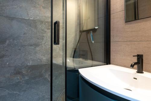 a bathroom with a sink and a glass shower at Appartement Ty Avel in Quiberon