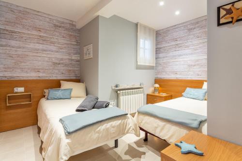 a bedroom with two beds and a table at Apartament Sant Antoni de Calonge in Sant Antoni de Calonge