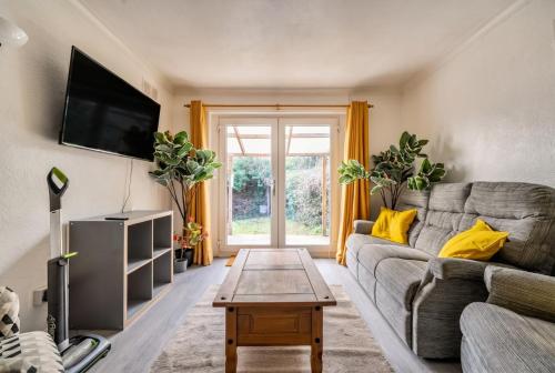 a living room with a couch and a tv at Bright 2-bed Bristol home with garden and parking in Bristol