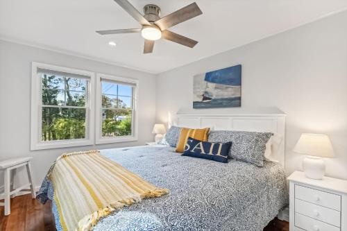 a bedroom with a bed and a ceiling fan at Steps to Beach + Sunset Views! East Marion Home in East Marion