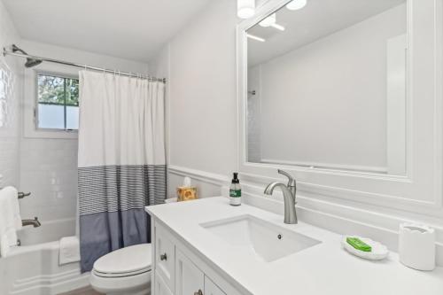 a white bathroom with a sink and a toilet at Steps to Beach + Sunset Views! East Marion Home in East Marion