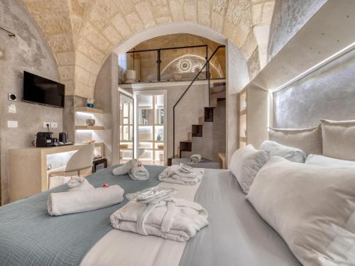 a bedroom with a bed with towels on it at SuiteCota24 piscina e spa in Lecce