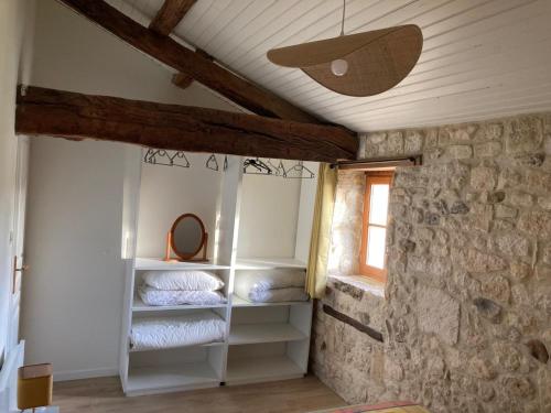 a room with white shelves in a stone wall at Au Charme Charentais Gite geel in Blanzaguet-Saint-Cybard-le-Peyrat