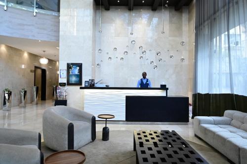 a man standing at a podium in a lobby at Royal Canaan Nairobi Hotel in Nairobi