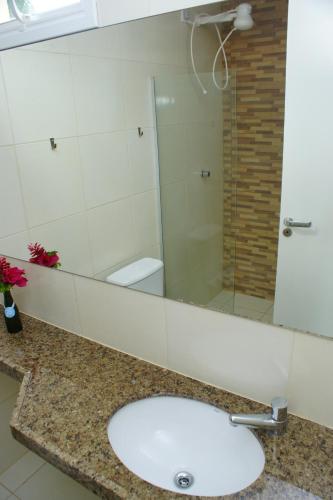 uma casa de banho com um lavatório e uma cabina de duche em vidro. em Pecem Beach Hotel - Aval Hotel em Pecém