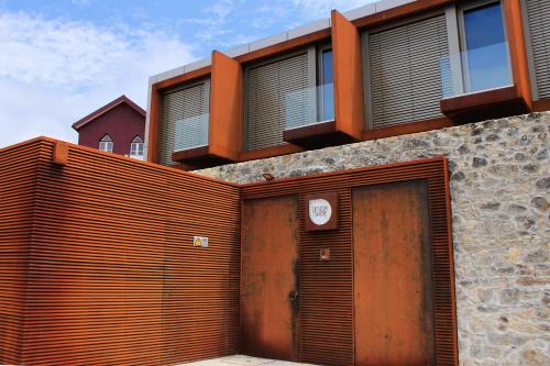 a building with a wooden gate and a wooden door at Design & Wine Hotel in Caminha