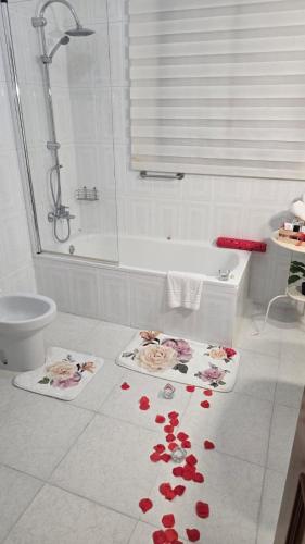 a bathroom with red flowers on the floor at Hotel Argos in Calasparra
