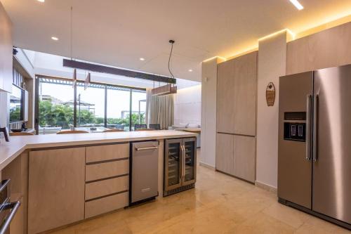 a large kitchen with stainless steel appliances and a large window at Coastal villa w dock access & pools u401 in Barú