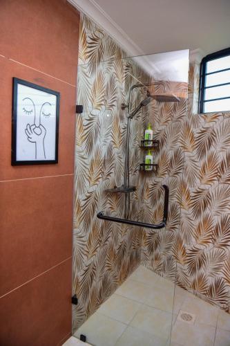 a shower in a bathroom with a wall at 2BR Forest Cabin, Jacuzzi, Fireplace & Mt Kenya Views in Naro Moru
