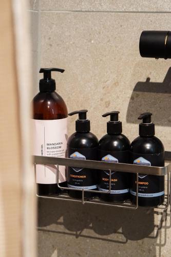 a rack with four bottles of soap and a bottle of alcohol at Modern One-Bedroom Apartment in Henningsvær in Henningsvær