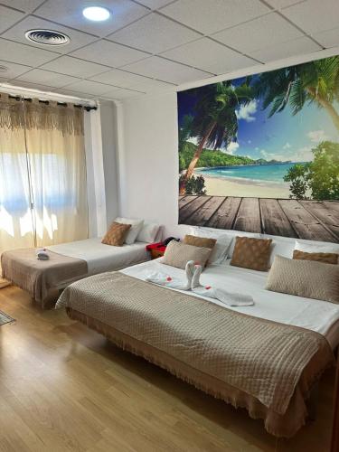 two beds in a room with a painting on the wall at Hotel Argos in Calasparra