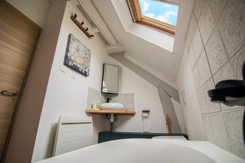 a small bathroom with a sink and a window at Le nid du Curtil - Chambre d'hôtes in Rougegoutte