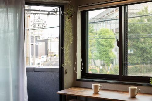 a window with two coffee cups on a wooden table at 翡翠名古屋本陣 in Nagoya