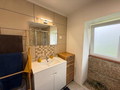 a bathroom with a sink and a window at Casa do Oliveira - Gerês in Terras de Bouro