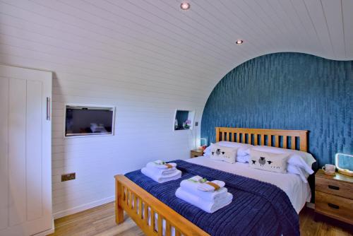 a bedroom with a bed with towels and a tv at Hollins Farm - Dog Friendly, Self Catering Holiday Lodges in Knaresborough