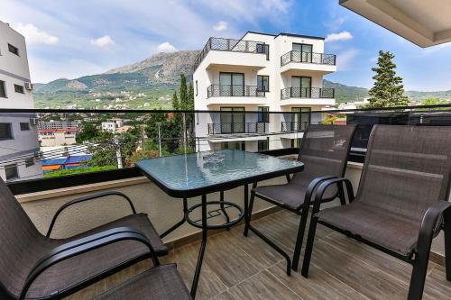 a balcony with chairs and a table and a view at Lux Apartmani Djukic in Bar