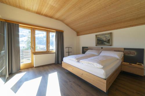 a bedroom with a bed and a large window at Chalet Stadel in Unterwasser