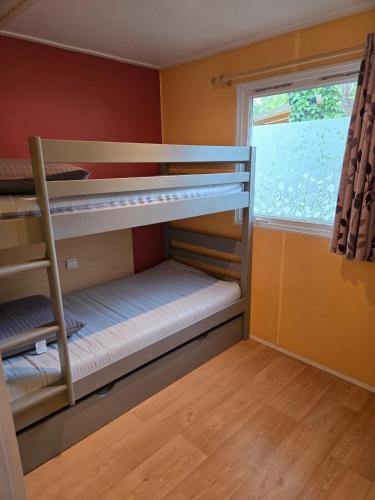 a bunk bed room with two bunk beds and a window at Iscles 231- MH Au calme près du lac in La Roque-dʼAnthéron