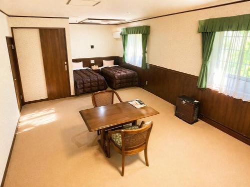 a room with a bedroom with a table and a bed at 森のうた Morinouta Forest Stay in Nikko in Nikko