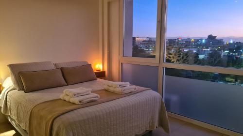 a bedroom with a bed with two towels on it at Bahía Grande Nordelta - con Cochera in Benavídez
