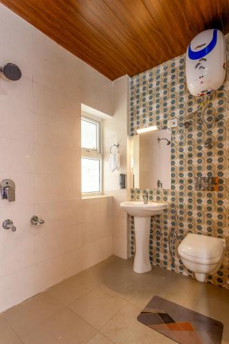 a bathroom with a toilet and a sink at Vamitag Inn in Shimla