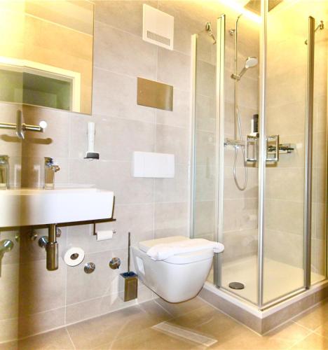 a bathroom with a shower and a toilet and a sink at Hotel Restaurant Zehn-Brunnen in Renningen