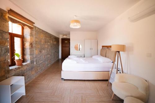 a bedroom with a bed and a chair at kastro konak in Gokceada Town
