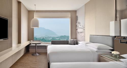 a hotel room with two beds and a window at Kathmandu Marriott Hotel in Kathmandu