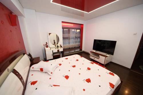 a bedroom with a bed and a flat screen tv at Ket Apartments in Galaţi