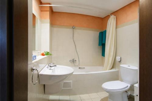 a bathroom with a toilet and a sink and a tub at El Mehdi Beach Resort ex Primasol El Mehdi in Mahdia
