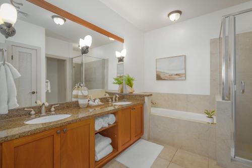 a bathroom with two sinks and a shower at Oceanfront Condo Halii Kai 14D in Waikoloa