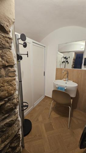 a bathroom with a sink and a chair at Casa Vacanza Zhurian in Ginestra