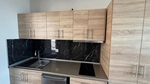 a kitchen with wooden cabinets and a sink at Coralli Apartments in Pefki