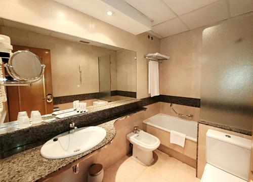ein Badezimmer mit Waschbecken, Toilette und Badewanne in der Unterkunft Hotel Imperial in Valladolid