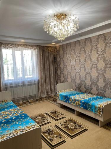a bedroom with two beds and a chandelier at Daniel guesthouse in Kochkorka