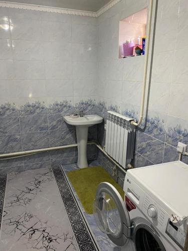 a bathroom with a sink and a washing machine at Daniel guesthouse in Kochkorka