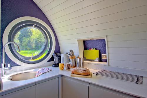 a bathroom with a sink and a round window at Hollins Farm - Dog Friendly, Self Catering Holiday Lodges in Knaresborough