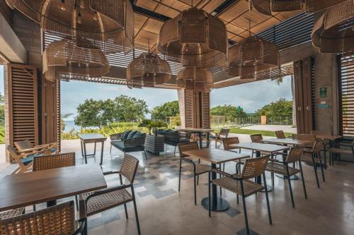 a restaurant with tables and chairs and a large window at Tropical villa w pool & dock access u501 in Barú