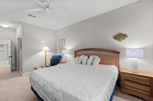 a bedroom with a large white bed and a nightstand at Marsh Breeze Hideaway at Masters Place in Pawleys Island