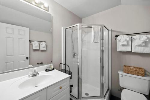 a white bathroom with a shower and a sink at Marsh Breeze Hideaway at Masters Place in Pawleys Island