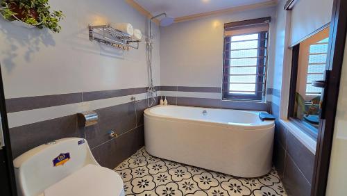a bathroom with a tub and a toilet at AM's Home in Ninh Binh