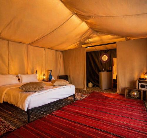 a bedroom with a bed in a tent at Campement authentique désert d Agafay in El Moukhtar
